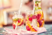 Zwei Gläser und ein Krug mit Himbeerdrink und Strohhalme Zwei Gläser und ein Krug mit Himbeerdrink und Strohhalme